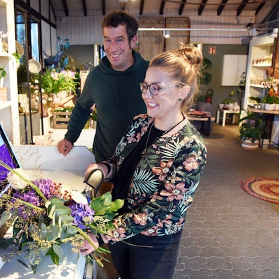 Das Foto zeigt die Inhaber der Gärtnerei am Selbstbedienungs-Terminal.
