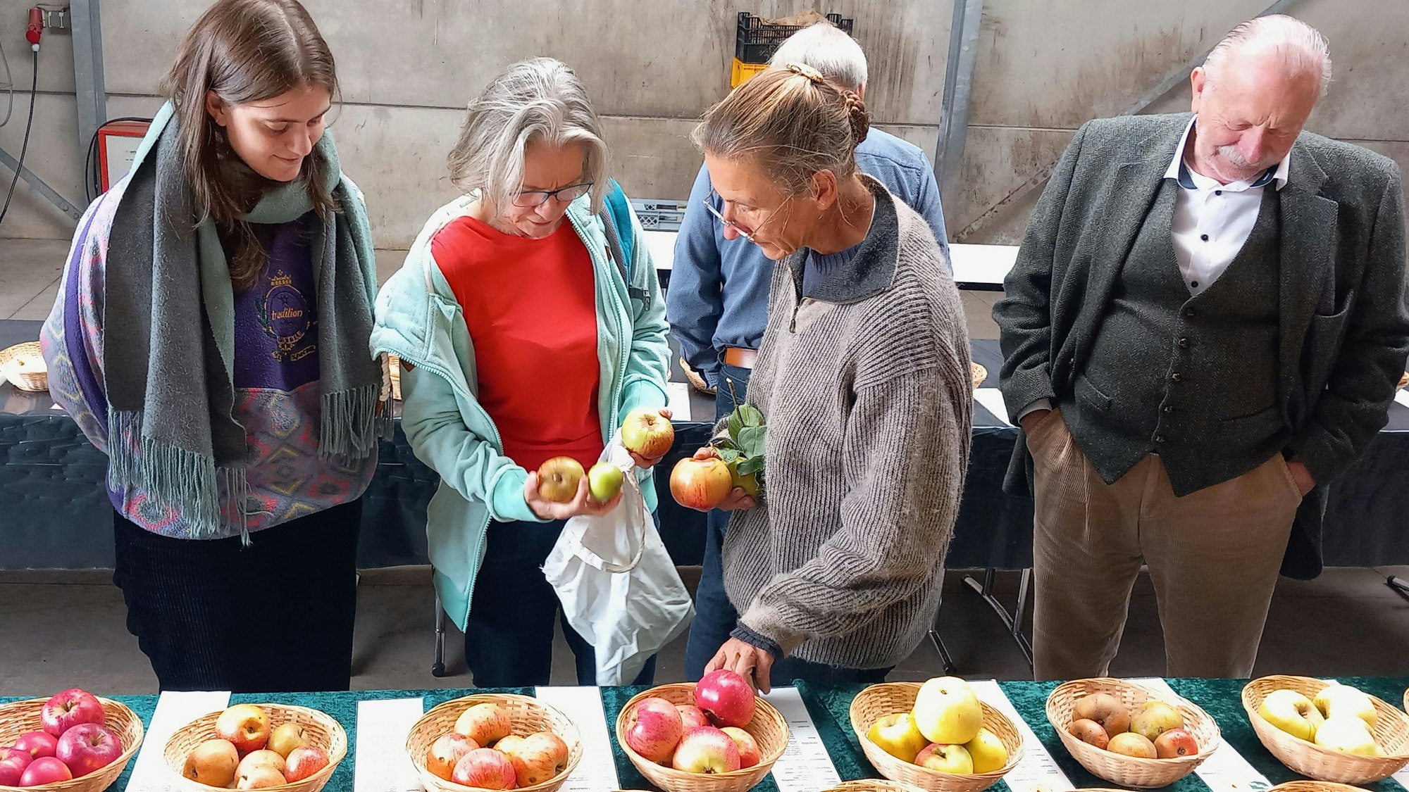 Barbara Bouillon (r.) erklärt einer Familie aus Bonn, welche Apfelsorte sie im Garten stehen hat.