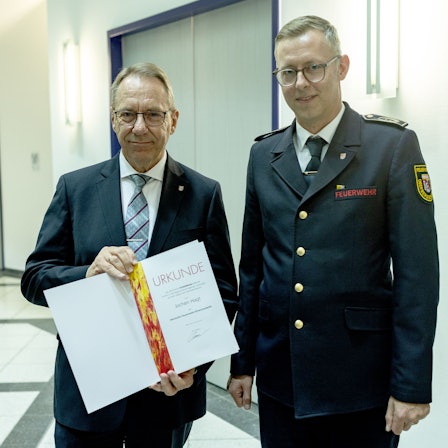 Jochen Hagt nimmt die Urkunde von Julian Seeger entgegen.