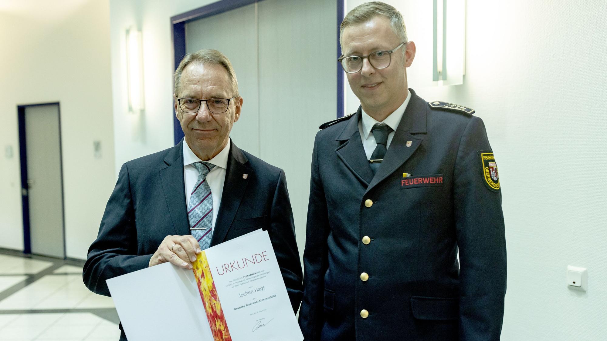 Jochen Hagt nimmt die Urkunde von Julian Seeger entgegen.