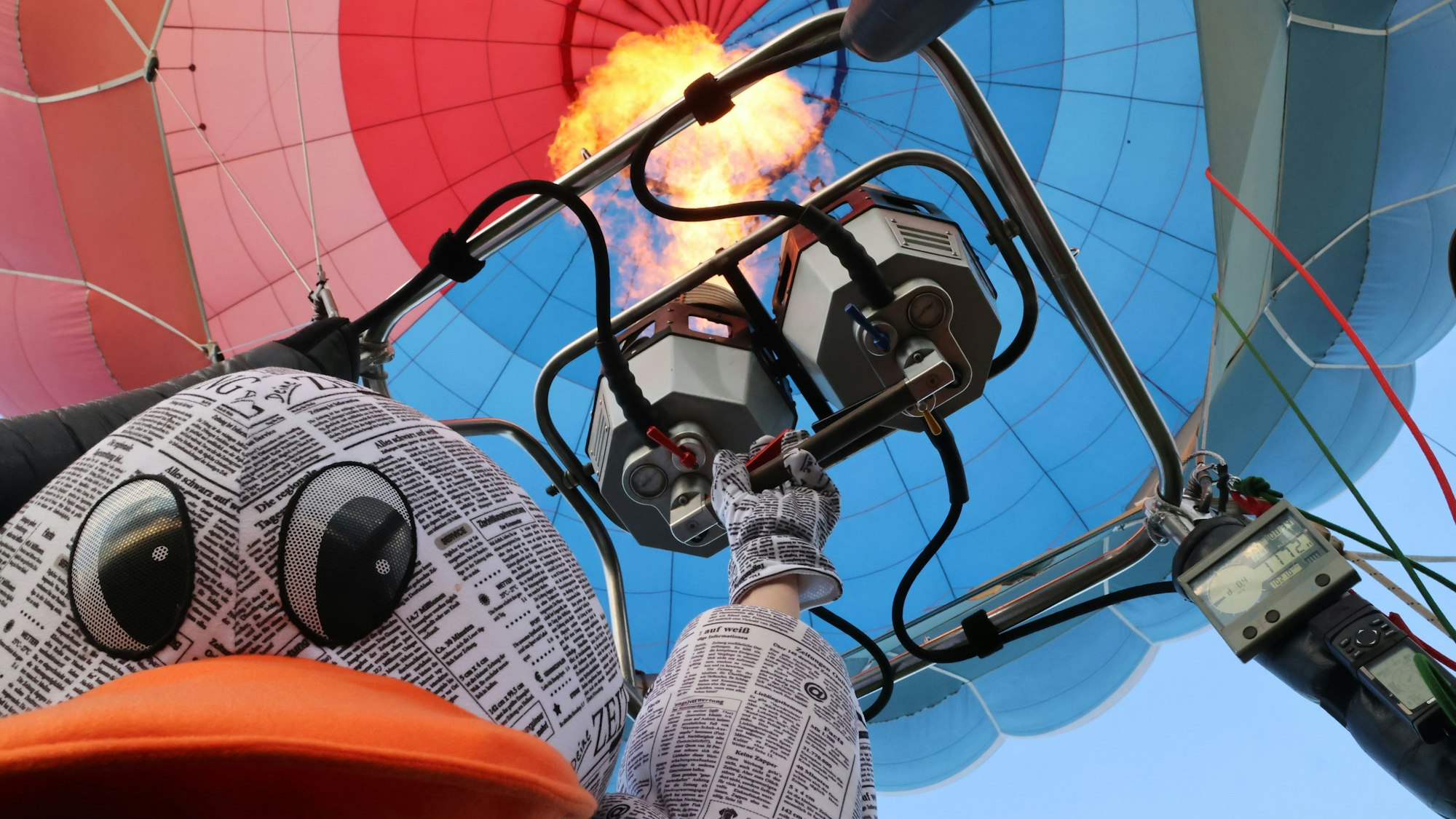 Eine Zeitungsente fliegt mit einem Heißluftballon.