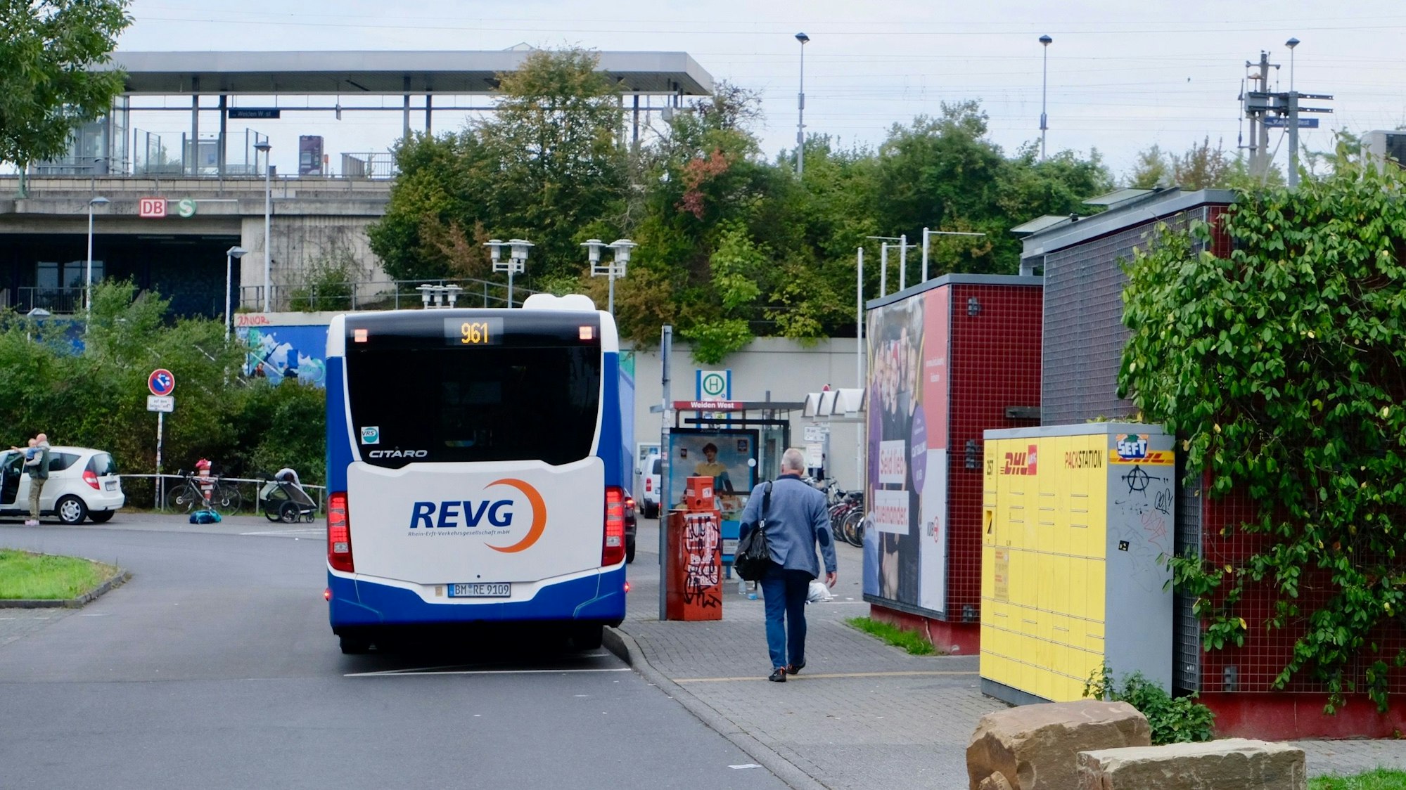 Ein Bus parkt an einer Haltestelle, im Hintergrund ist die Station der Stadtbahnlinie zu sehen.
