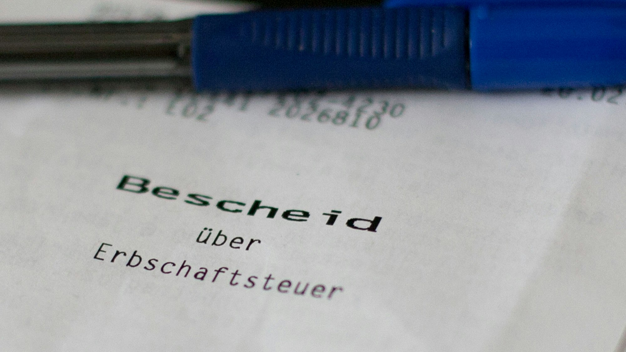 Ein Bescheid über die Erbschaftssteuer liegt auf einem Schreibtisch.