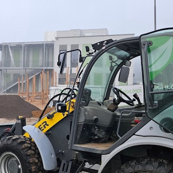 Zu sehen ist die Baustelle für einen Kindergarten mit einem Radlader und einem kleinen Bagger.