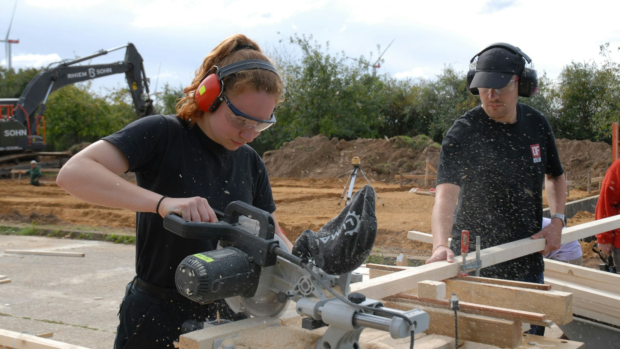 Eine Frau und ein Mann sägen Holz.