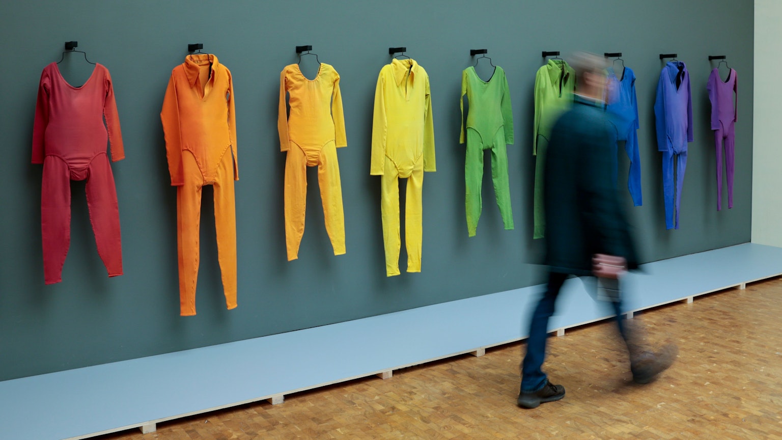 Köln: Ein Besucher geht bei einer Vorbesichtigung der Ausstellung „Fünf Freunde“ im Museum Ludwig an den aufgehängten Tanzkostümen von der Aufführung von Merce Cunninghams „Herzschlag“-Bewegung vorbei.