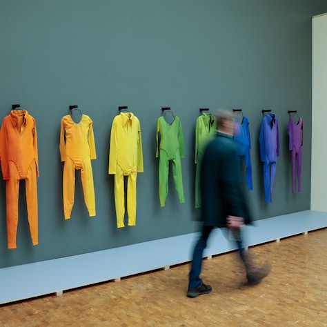 Köln: Ein Besucher geht bei einer Vorbesichtigung der Ausstellung „Fünf Freunde“ im Museum Ludwig an den aufgehängten Tanzkostümen von der Aufführung von Merce Cunninghams „Herzschlag“-Bewegung vorbei.