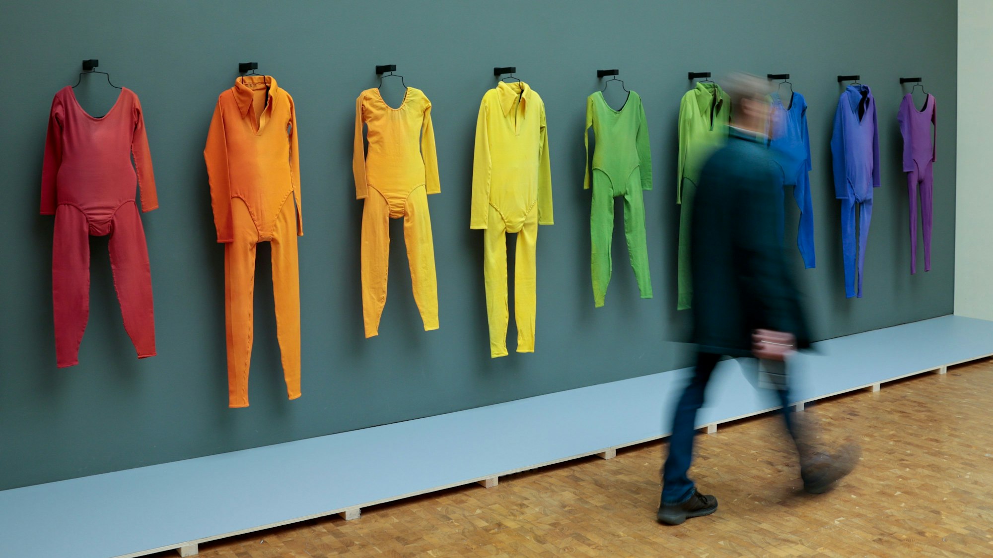 Köln: Ein Besucher geht bei einer Vorbesichtigung der Ausstellung „Fünf Freunde“ im Museum Ludwig an den aufgehängten Tanzkostümen von der Aufführung von Merce Cunninghams „Herzschlag“-Bewegung vorbei.