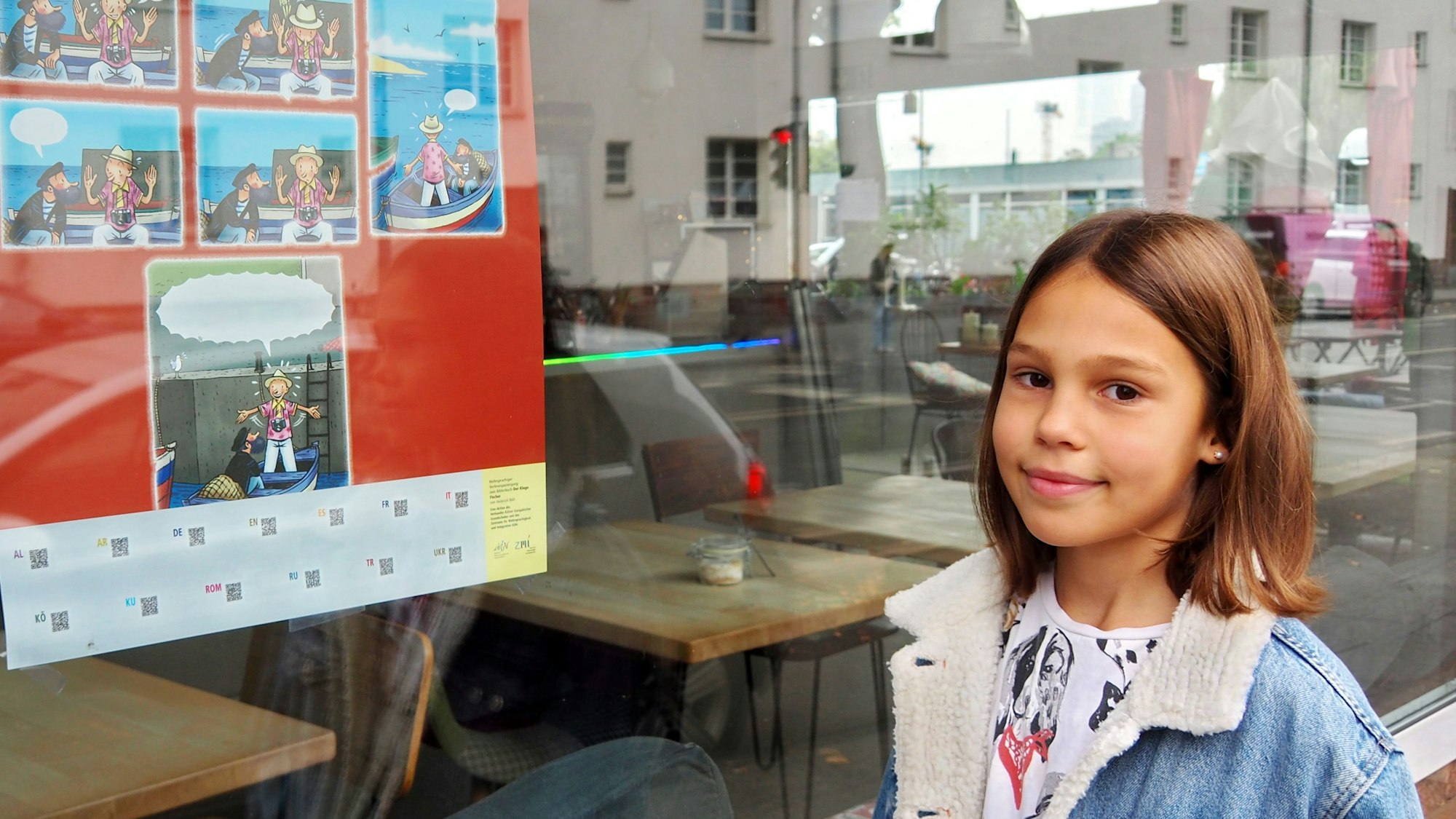 Ein Mädchen steht vor dem Fenster eines Cafés. Darin hängt ein Plakat mit dem Hinweis auf den Vorlesespaziergang.
