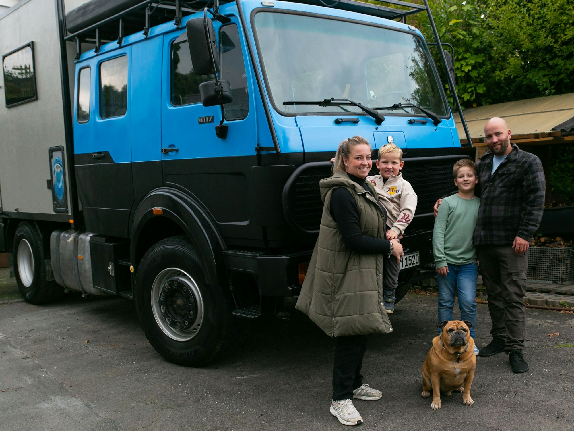 Ein Familiengruppenfoto vor einem blauen Expeditionsmobil.