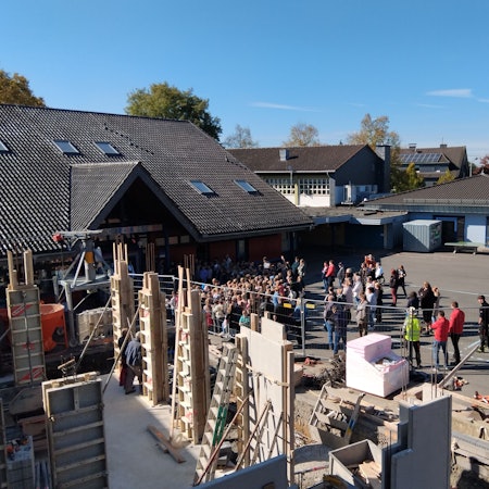 Beim Richtfest der Grundschule Much-Marienfeld sangen die Kinder ein Lied. Das erste Gebäude steht im Rohbau, das zweite wächst auf dem Schulhof.