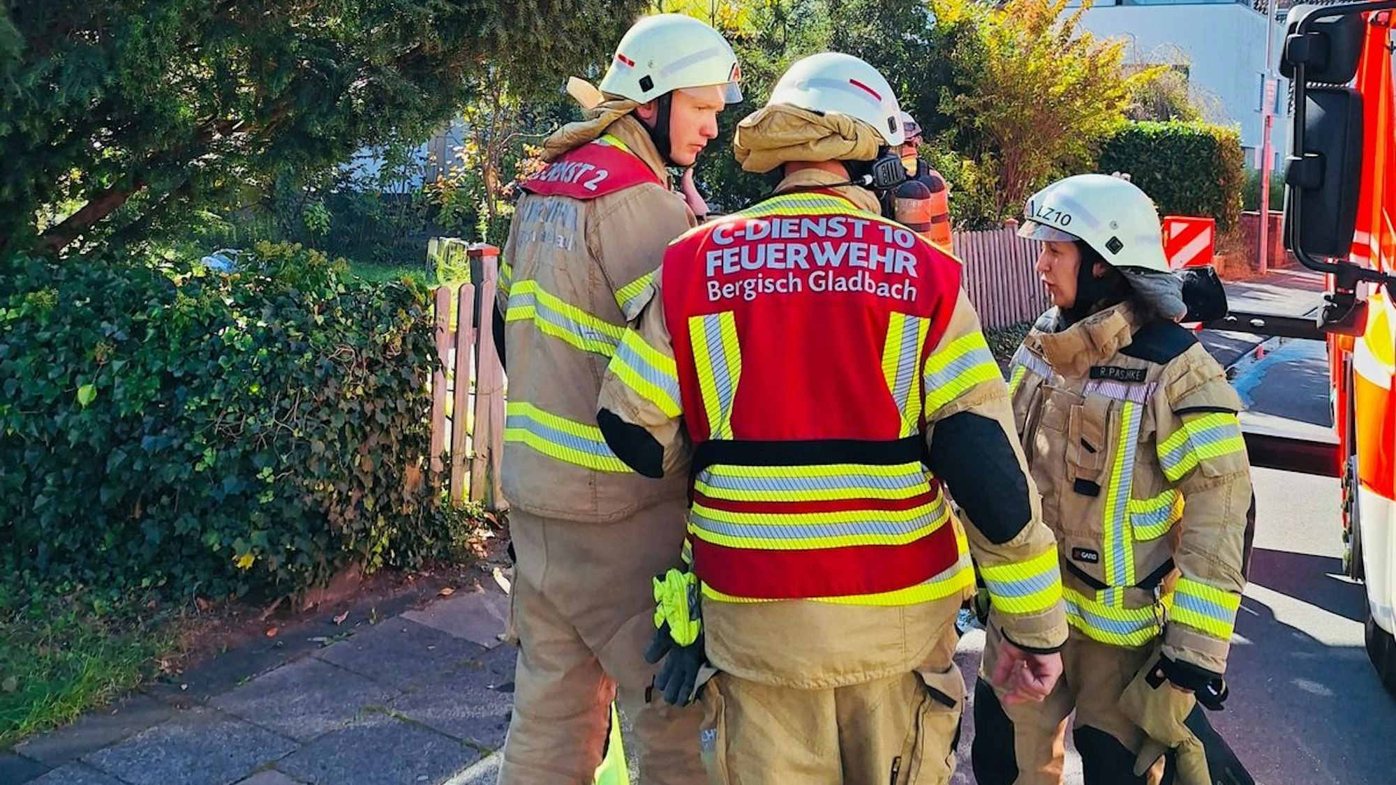 Feuerwehrleute stehen auf einer Straße in Bergisch Gladbach.