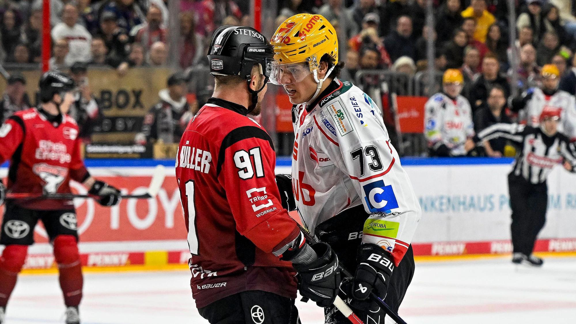 HItziges Duell: Haie-Kapitän Moritz Müller (l. Nr.91) und Bremerhavens Bennet Roßmy stehen Kopf an Kopf.