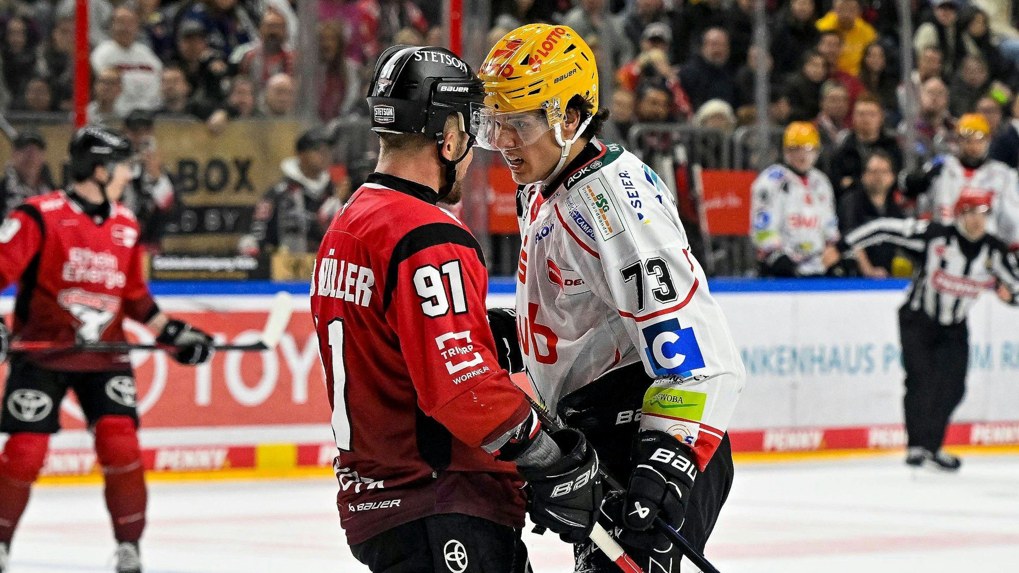 HItziges Duell: Haie-Kapitän Moritz Müller (l. Nr.91) und Bremerhavens Bennet Roßmy stehen Kopf an Kopf.