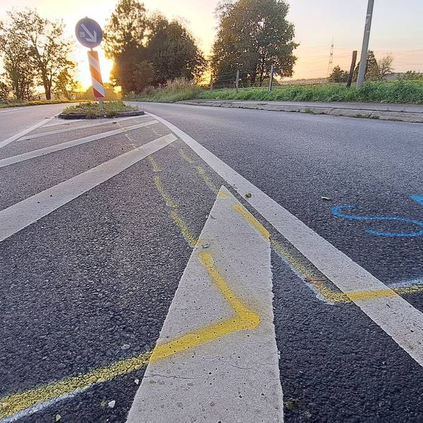 Unfallmarkierungen sind auf der Kreisstraße bei Rösrath-Stöcken vor einer Verkehrsinsel zu sehen.
