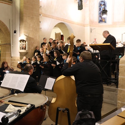Blick über das Orchester auf die Sänger im Chorraum.