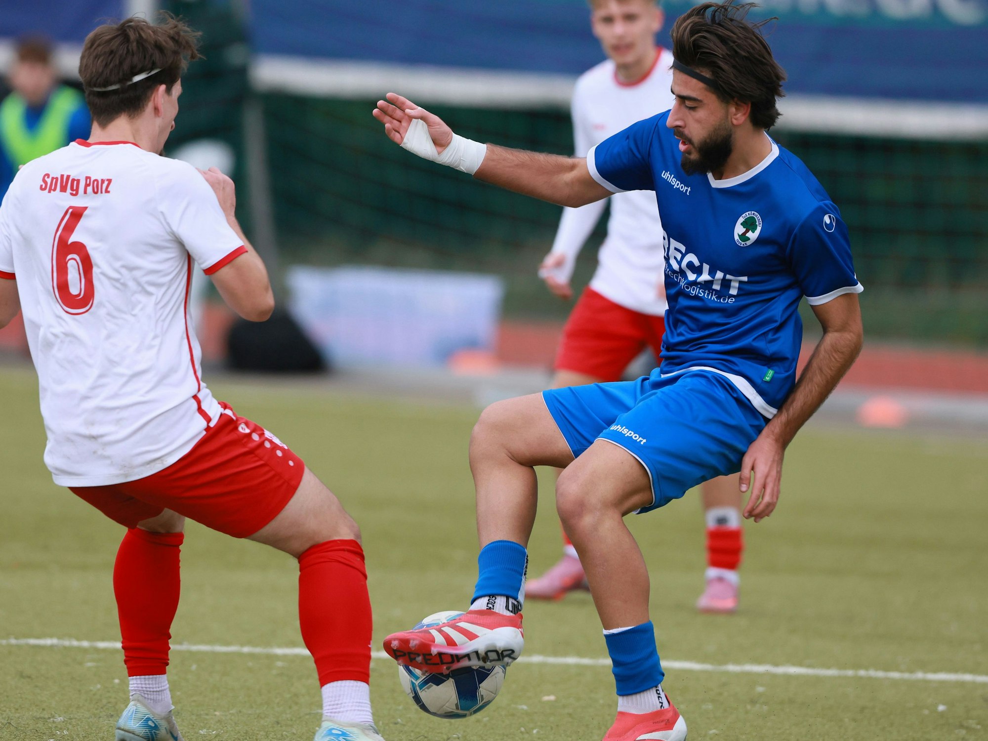 Das Bild zeigt einen Königsdorfer Fußballer (r.), der den herannahenden Porzer Gegenspieler mit Ball narrt.