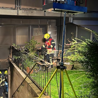 Zu sehen sind Feuerwehrleute beim Einsatz an dem Mehrfamilienhaus in Bergheim-Niederaußem.