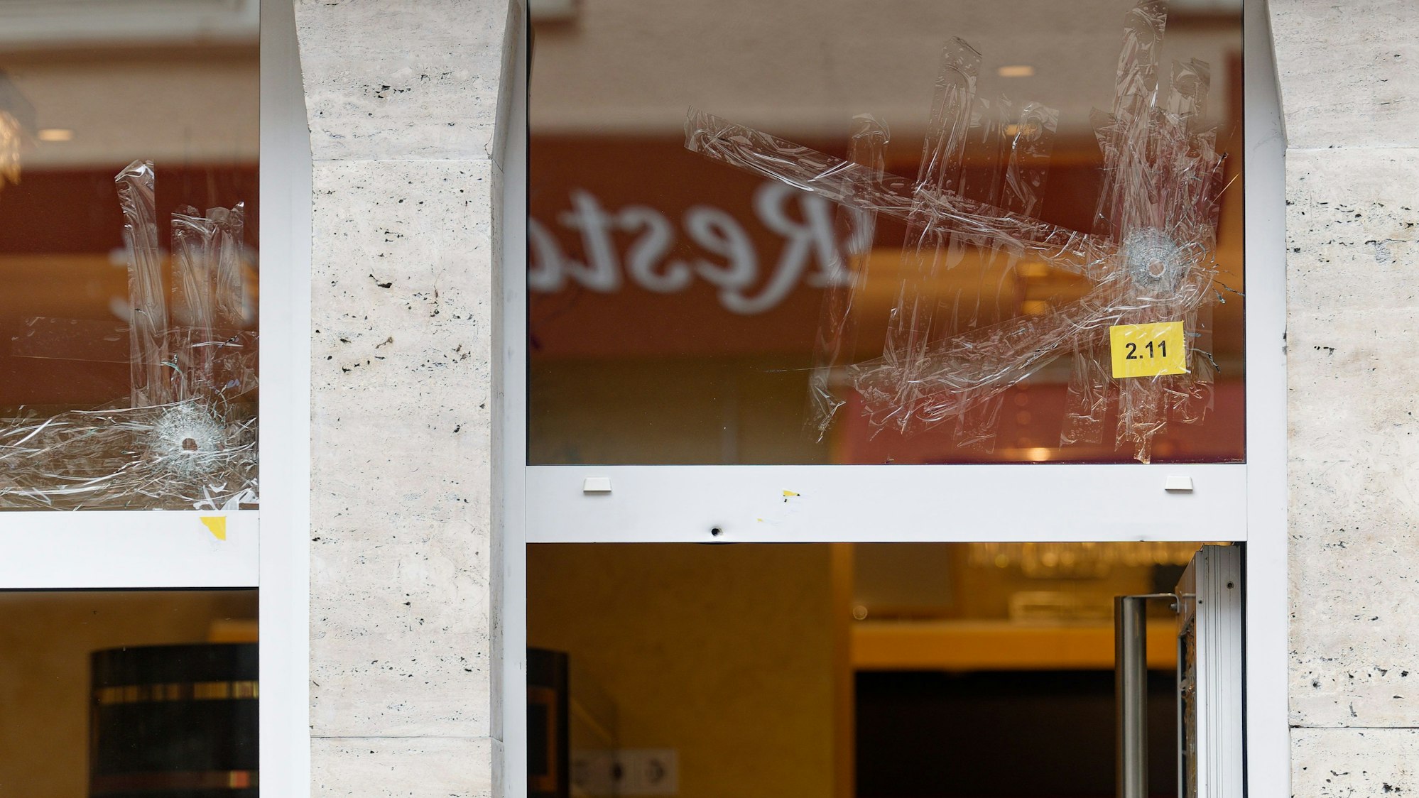 Einschusslöcher sind in einem Fenster über dem Eingang zu einer Konditorei zu sehen.