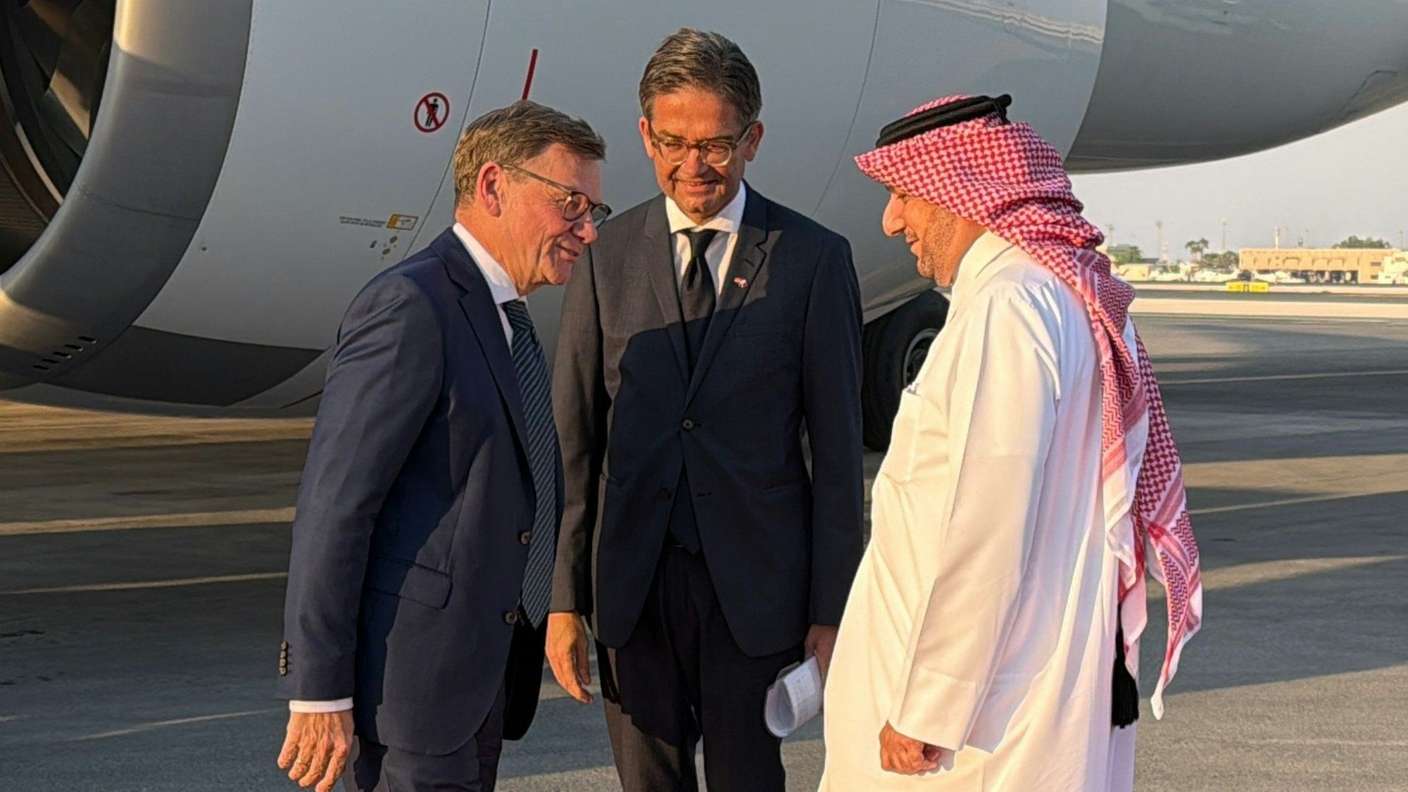 05.10.2025, Katar, Doha: Außenminister Johann Wadephul (CDU, l) wird bei seiner Ankunft in Doha durch den Chef des katarischen Protokolls, Ibrahim Fakhroo (r), und den deutschen Botschafter Oliver Owcza (M) begrüßt. Foto: Jörg Blank/dpa +++ dpa-Bildfunk +++