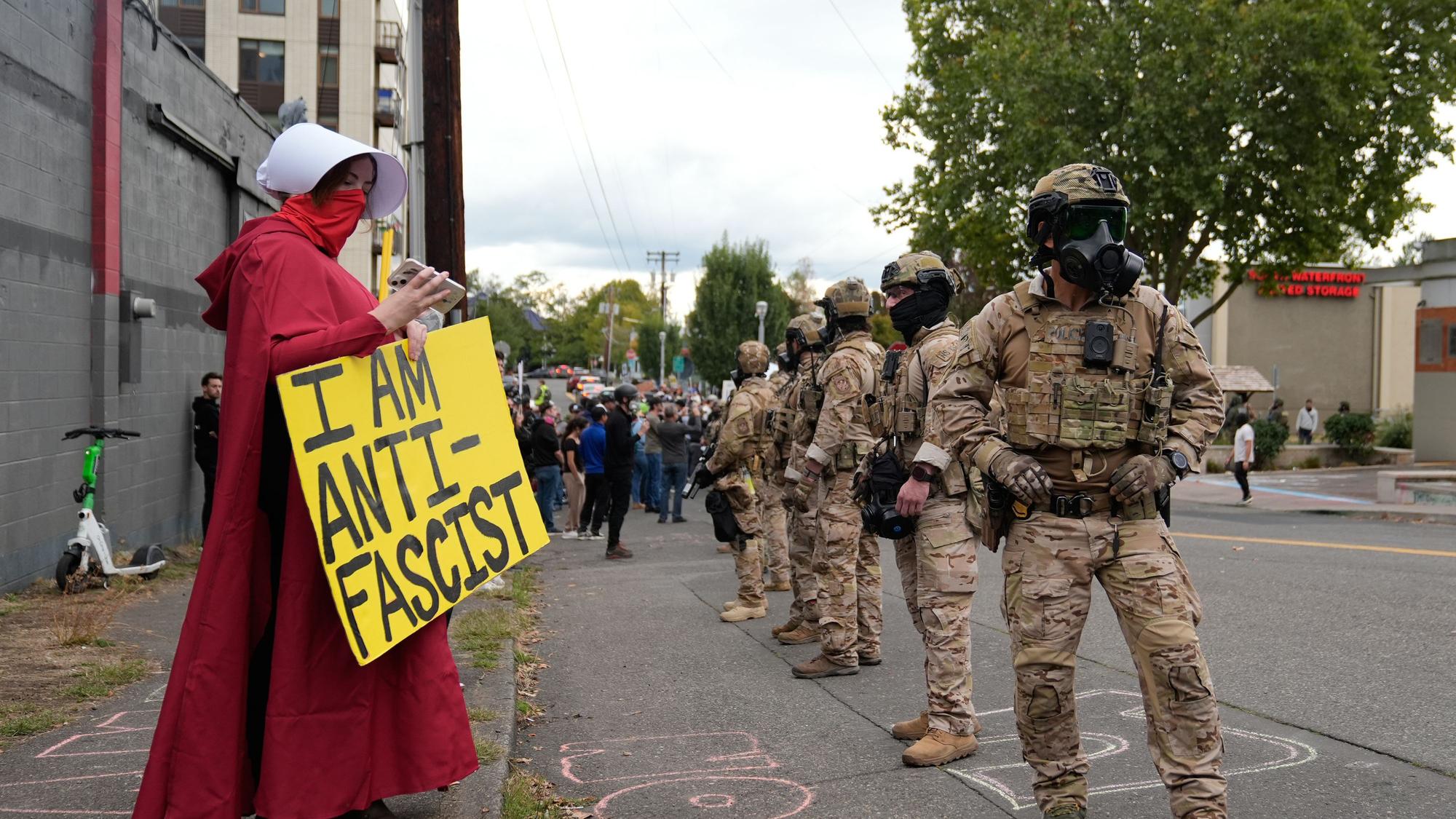 dpatopbilder - 04.10.2025, USA, Portland: Beamte der Zoll- und Grenzschutzbehörde stehen vor Demonstranten vor einer Einrichtung der US-Einwanderungs- und Zollbehörde während einer Demonstration. Foto: Jenny Kane/AP/dpa +++ dpa-Bildfunk +++