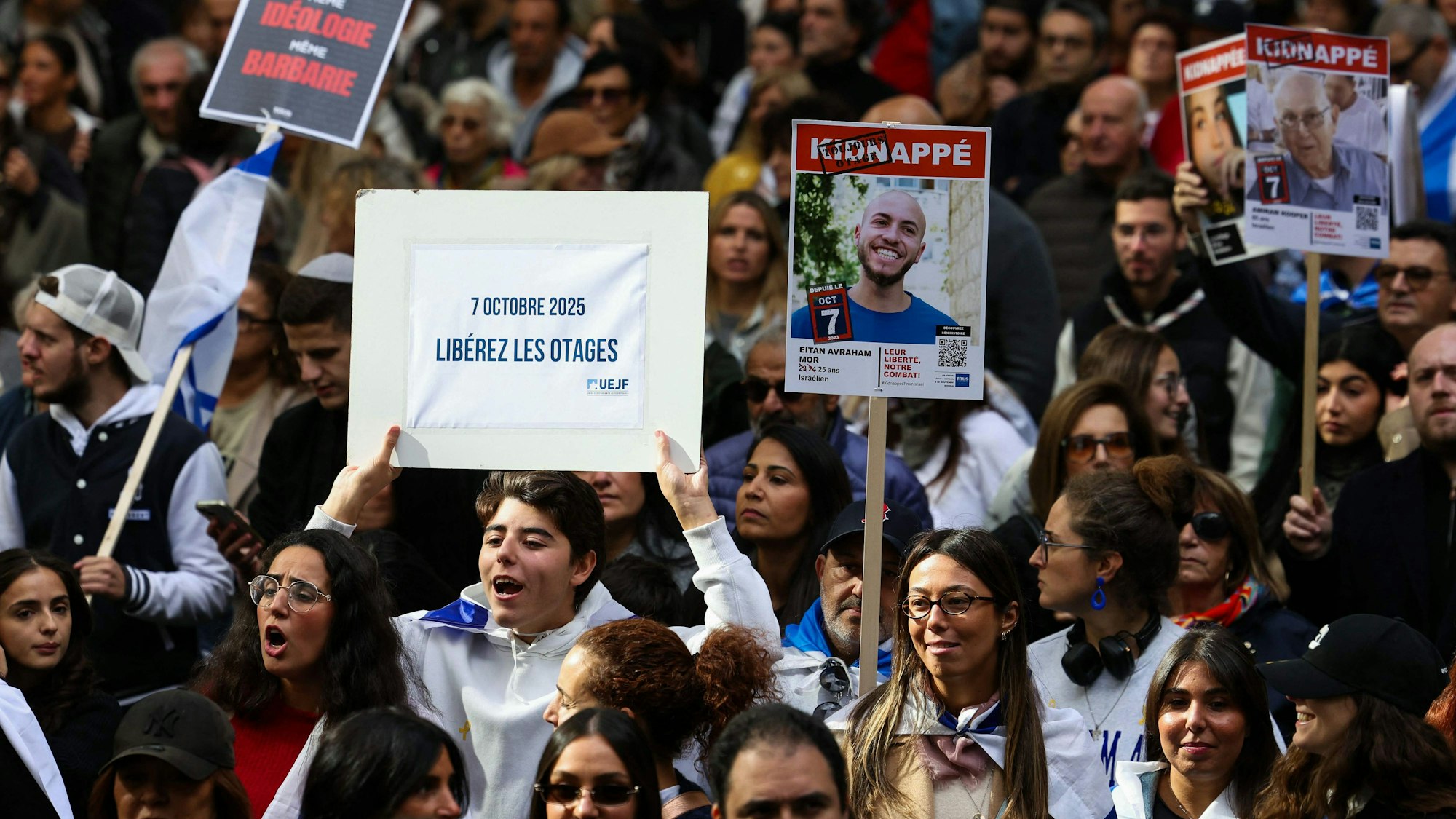 A protestor holds a sign reading "Free the hostage" during a march to ask for the release of the hostages held in the territory of Gaza, in Paris on October 5, 2025. Israeli and Hamas negotiators were converging on Cairo on October 5, 2025 for talks to end nearly two years of war in Gaza, with Israel's leader expressing hope that hostages held in the devastated territory could be released within days. (Photo by Thomas SAMSON / AFP)