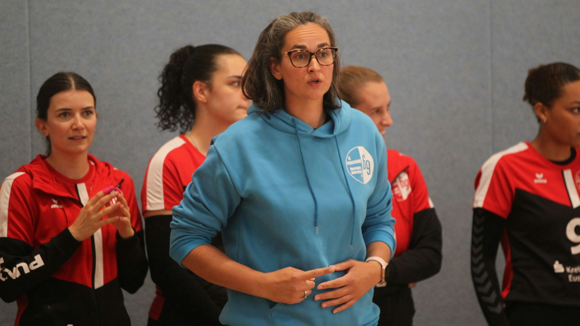 Marmagens Trainerin Sandy Falkenstein zeigt mit dem Zeigefinger der rechten Hand etwas verdeckt an.