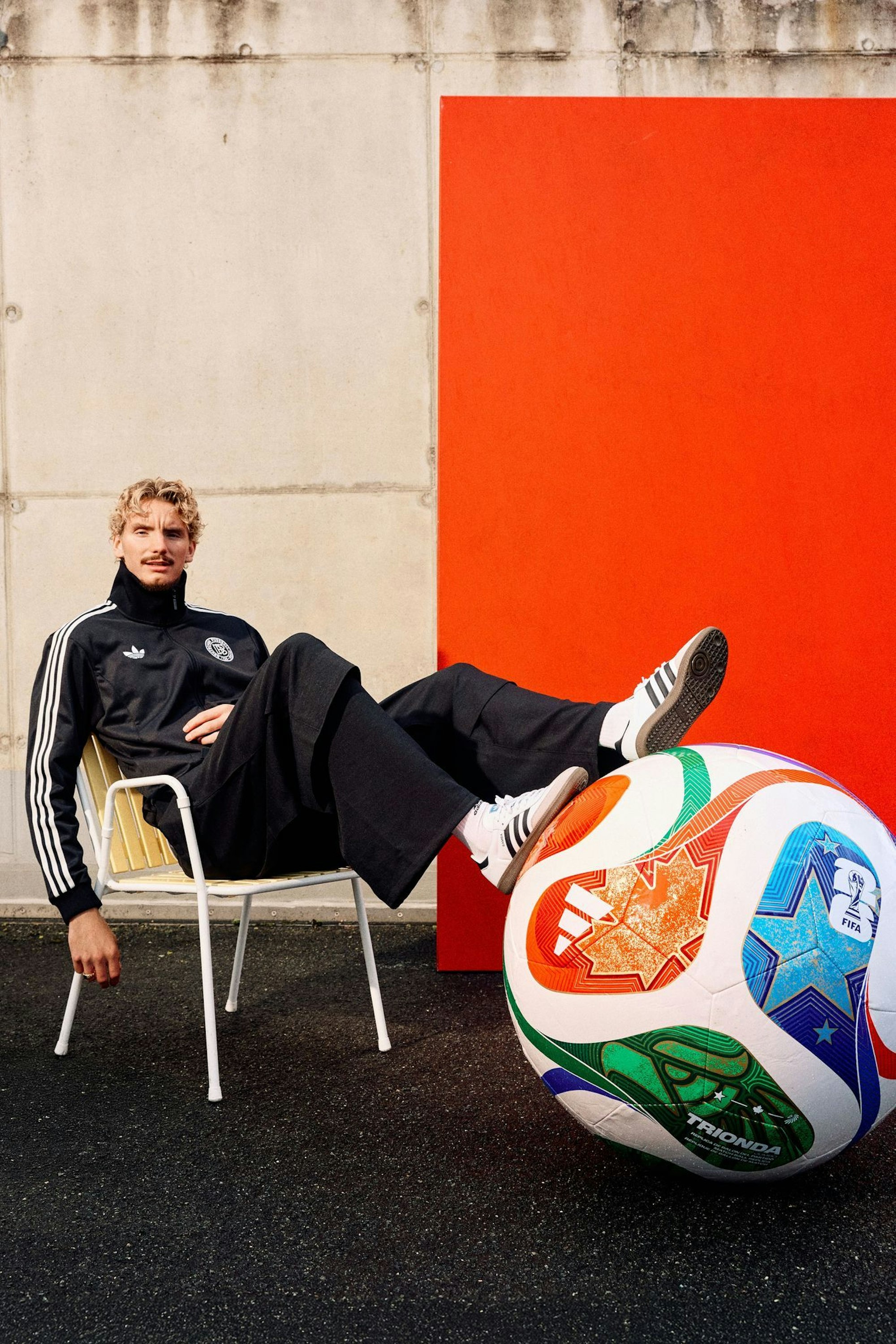 Woltemade posiert lässig mit dem übergroßen Modell des WM-Balls.