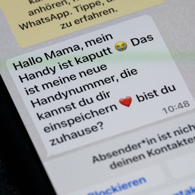 Ein Handy mit einer Betrüger-Nachricht per Whatsapp.