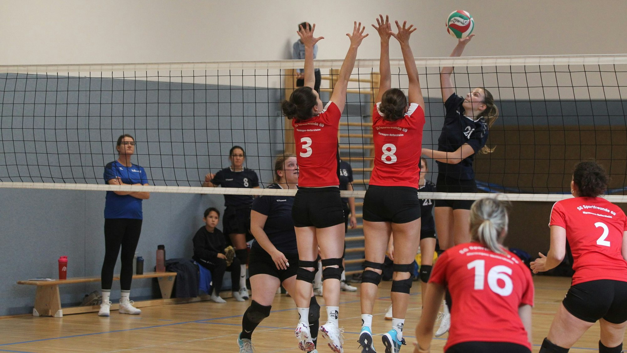Volleyballer der Sportfreunde 69 und von Stotzheim in roten und schwarzen Trikots spiel gegeneinander.