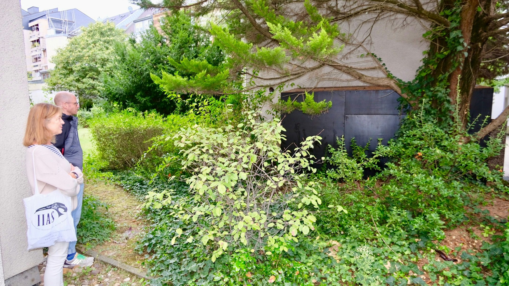 Lydia Kieven und Sven Röhrig an der Quelle des Lärms, der „eingehausten“ Kühlanlage im Innenhof. Im Inneren des schwarzen Kastens befinden sich die Außengeräte der Kühlanlage.
