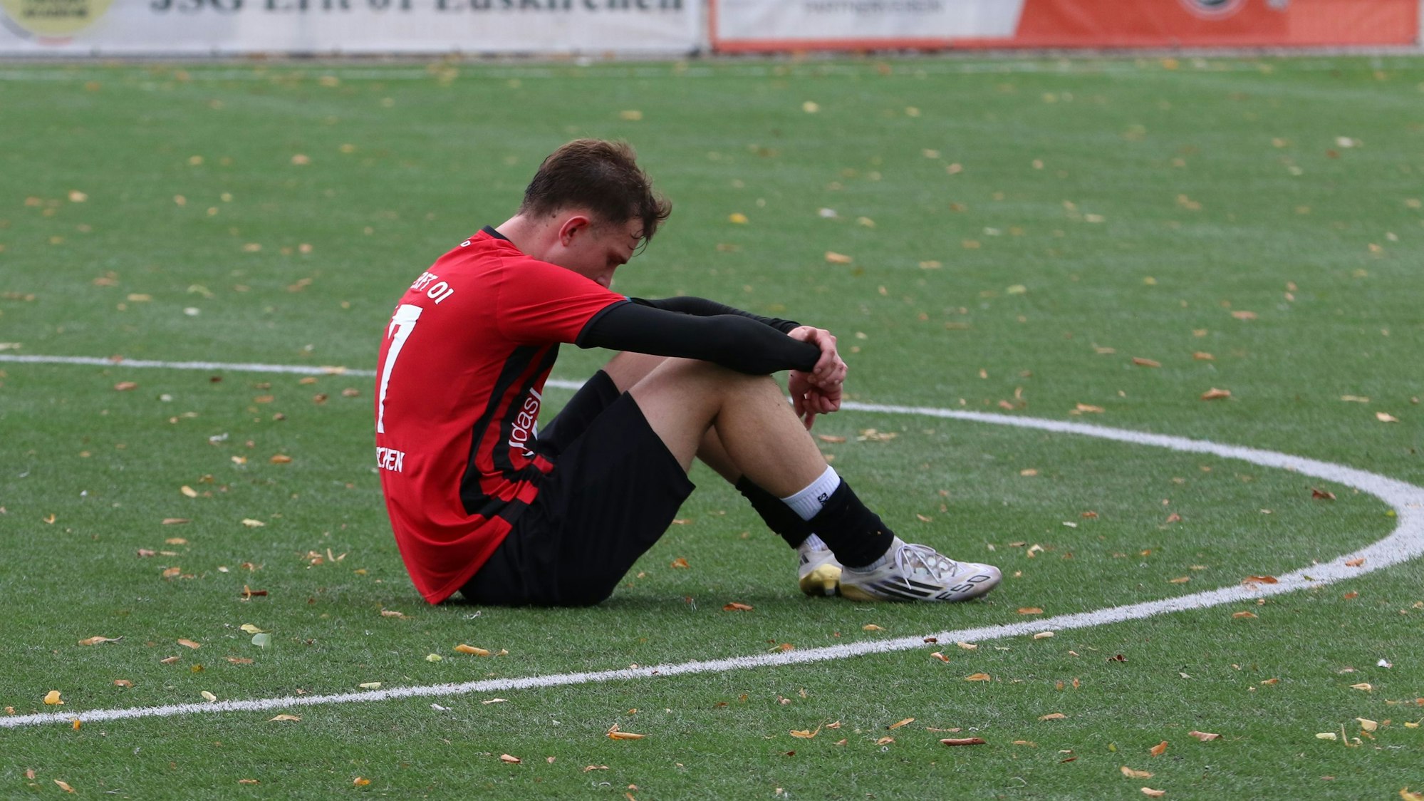 Artur Schulz sitzt im Mittelkreis auf dem Boden.