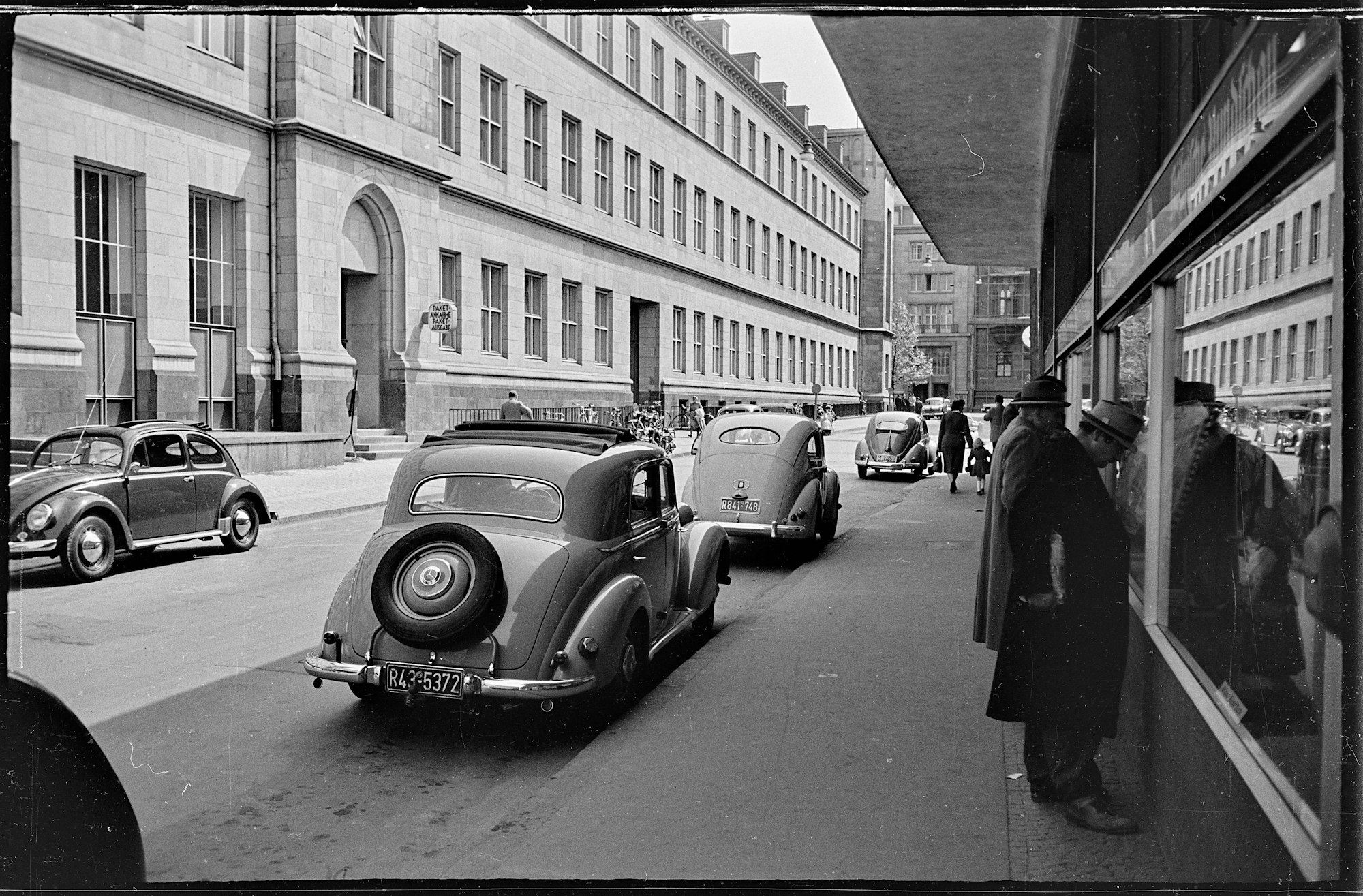Köln - das Hauptpostamt in der Stolkgasse, welches sich seit 1893 (da als Reichshauptpostamt) in den Gebäuden des zwischen Marzellenstraße und Stolkgasse gelegenen ehemaligen Dominikanerklosters befand. - Auf der rechten Seite das Gebäude der Kölnischen Rundschau mit seinem Zeitungs-Aushang. - Foto aus 05.1955