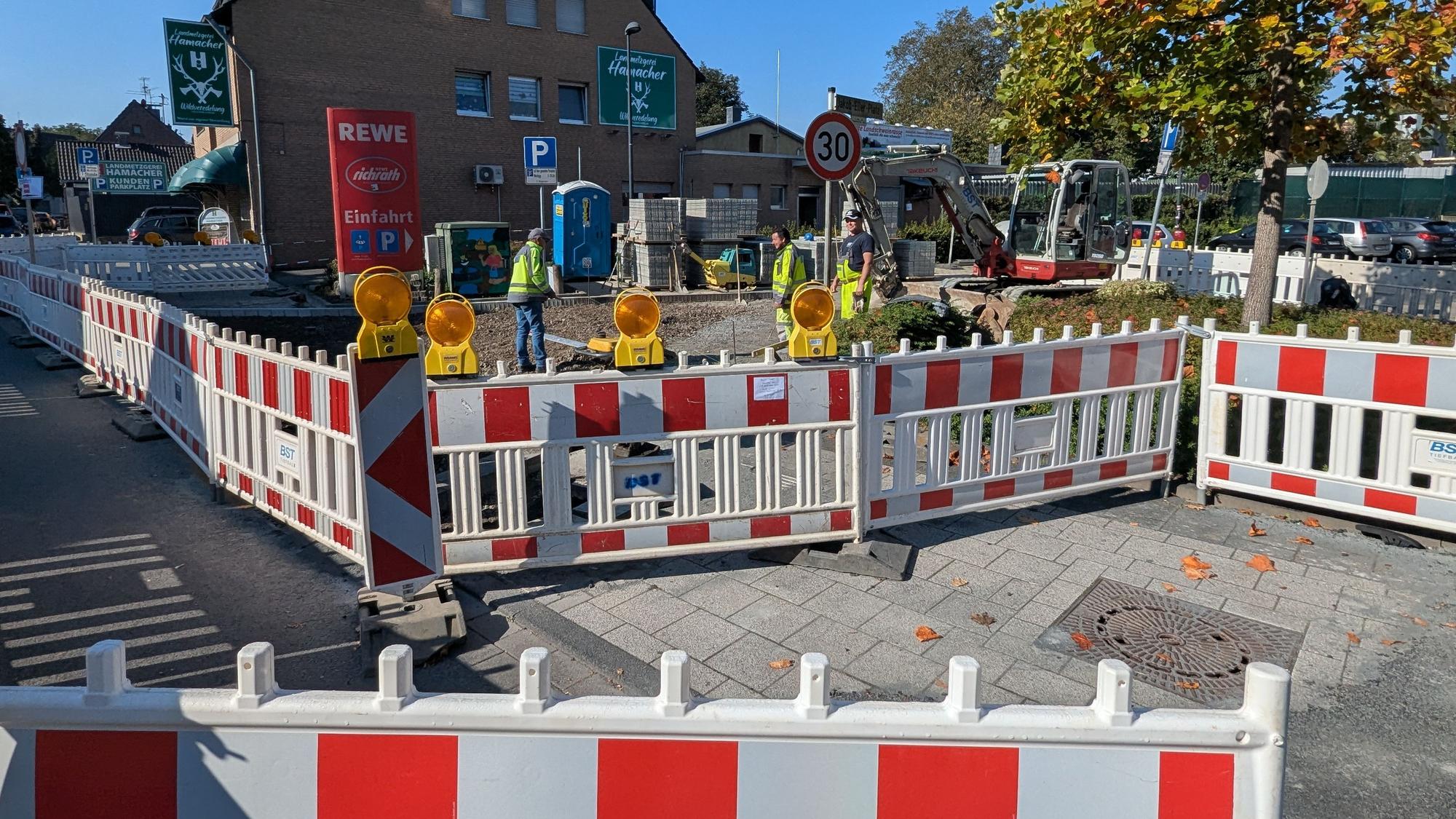 Das Foto zeigt die Bauarbeiten mit einem Bagger hinter Bauzäunen.
