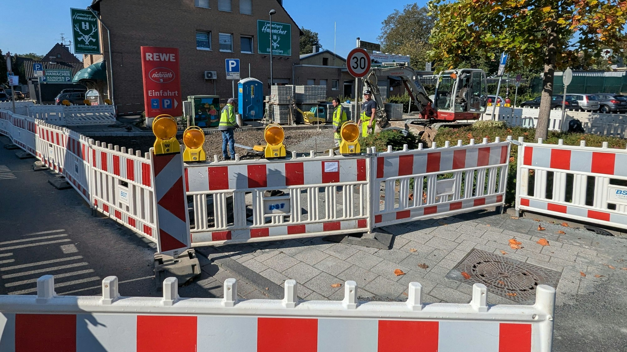 Das Foto zeigt die Bauarbeiten mit einem Bagger hinter Bauzäunen.