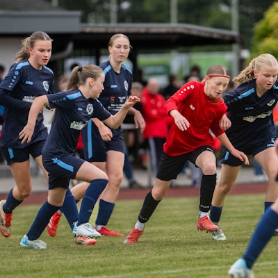 Zülpichs Sophia Kesseler im roten Trikot ist umringt von Spielerinnen des VfL Kommern.