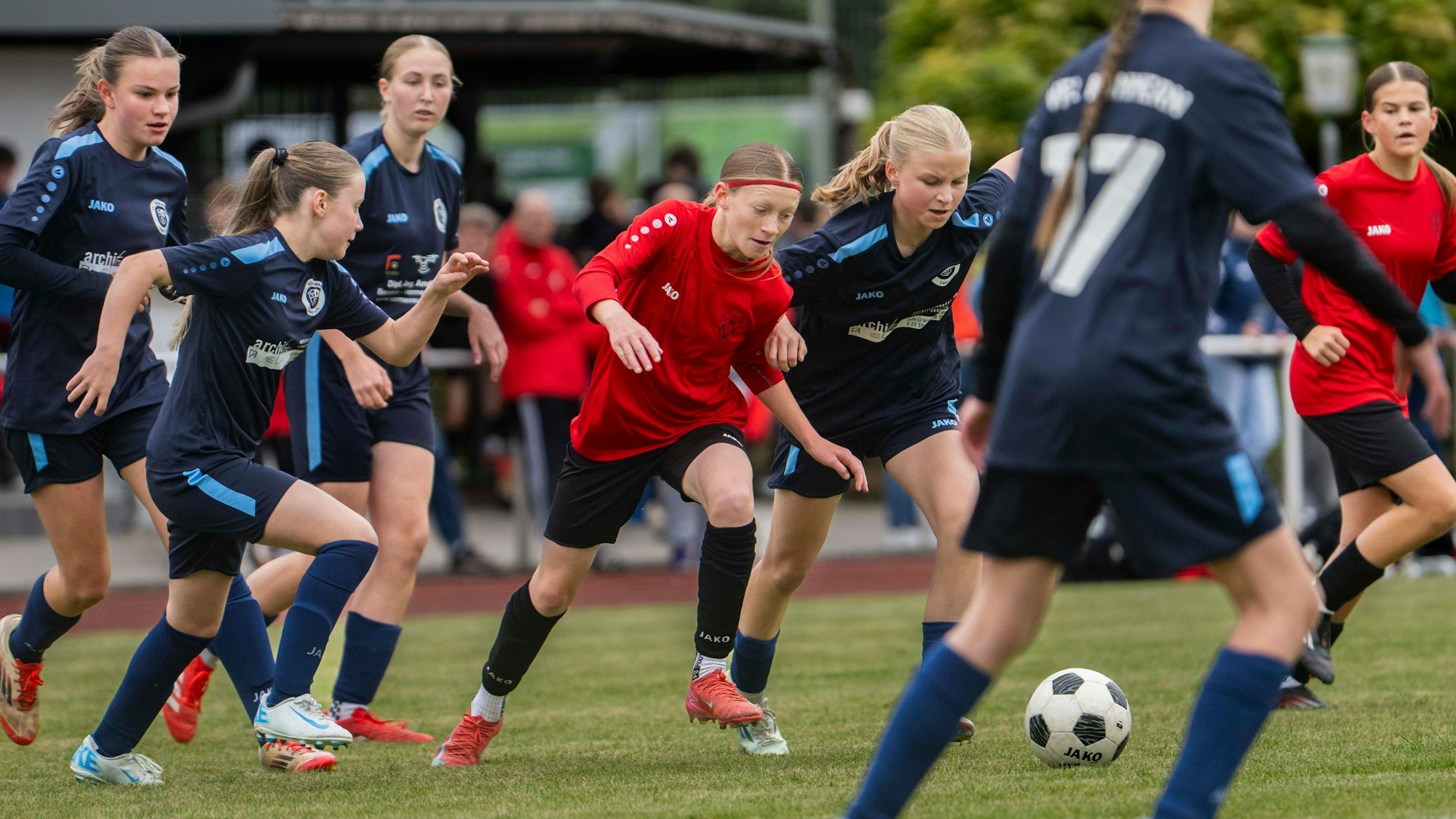 Zülpichs Sophia Kesseler im roten Trikot ist umringt von Spielerinnen des VfL Kommern.