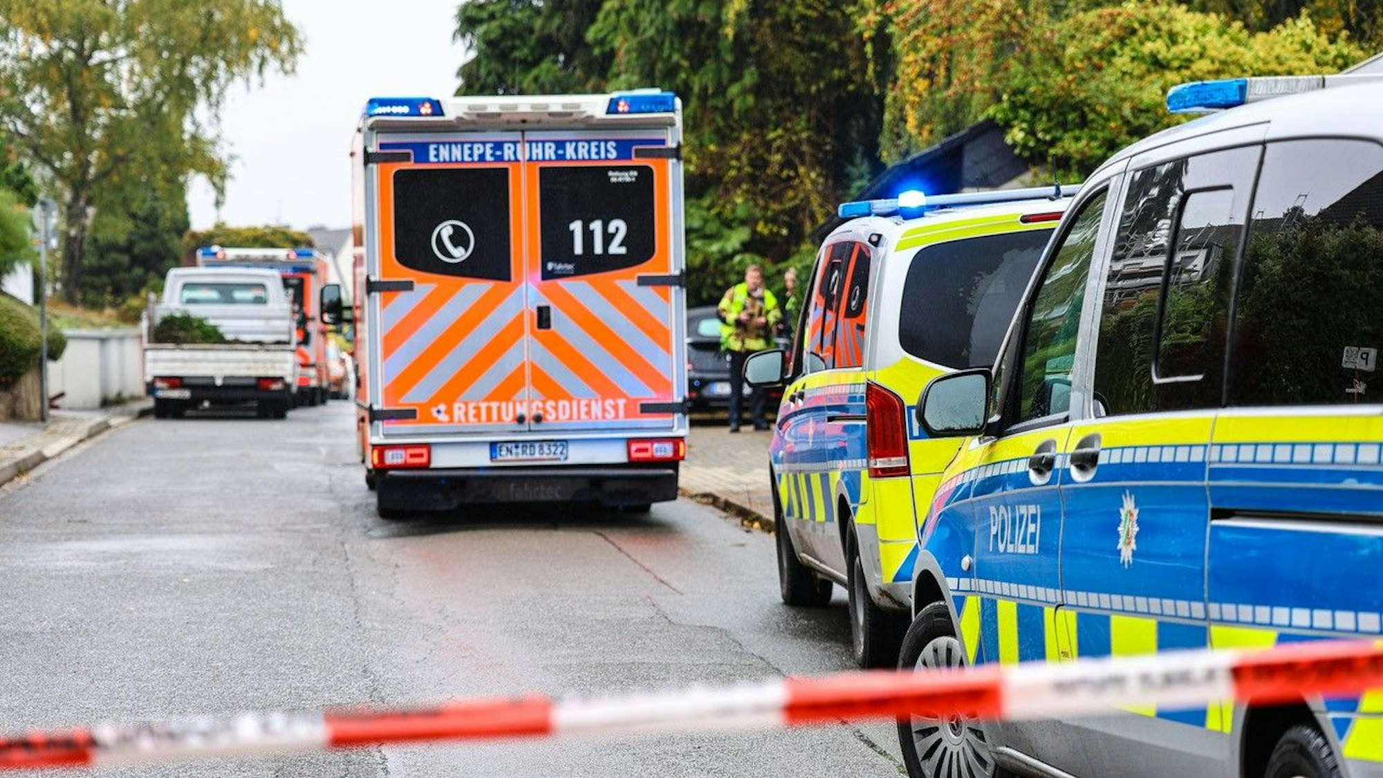 Ein Krankenwagen und Einsatzwagen der Polizein stehen nahe des mutmaßlichen Tatorts.