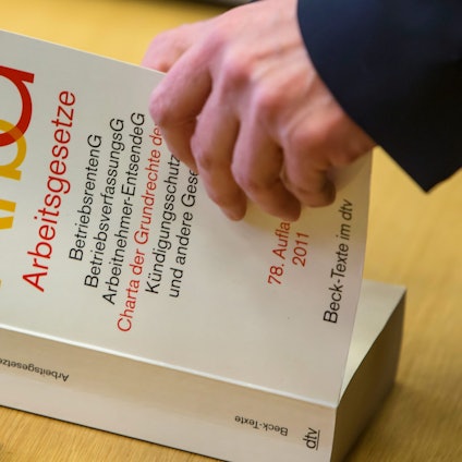 Das Symbolbild zeigt ein Buch mit den Arbeitsgesetzen.