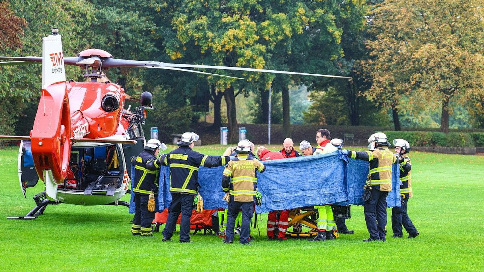 Einsatzkräfte stehen neben einem Rettungshubschrauber. Die neu gewählte Bürgermeisterin von Herdecke, Iris Stalzer (SPD), ist lebensgefährlich verletzt in ihrer Wohnung gefunden worden.
