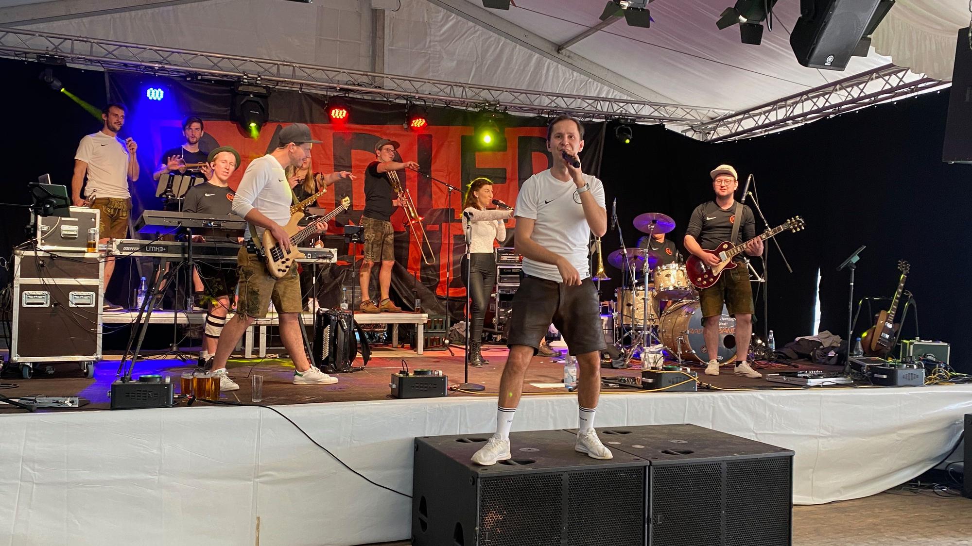 Eine Band steht auf einer Bühne.