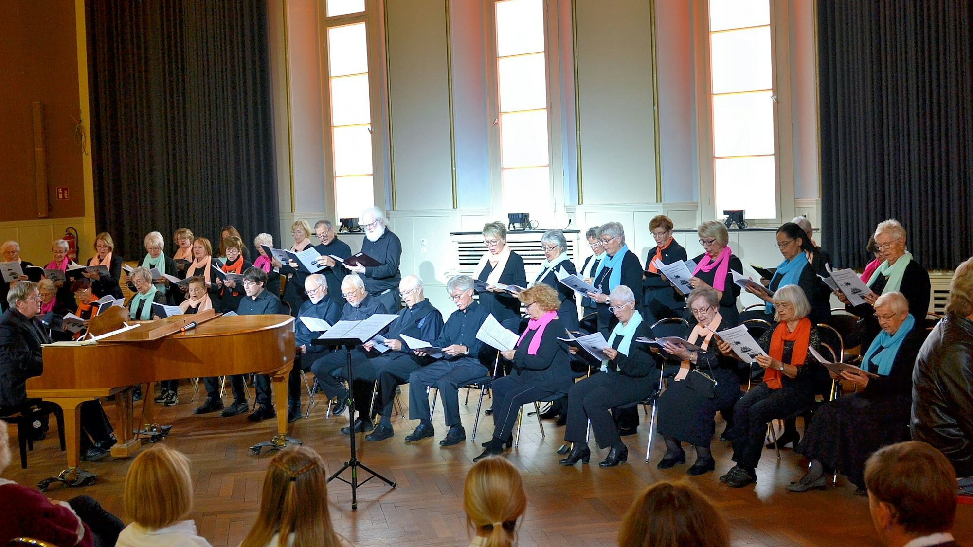 Auf der Bühne des Casinos stehen und sitzen die Mitglieder des Sängerkreises Euskirchen.
