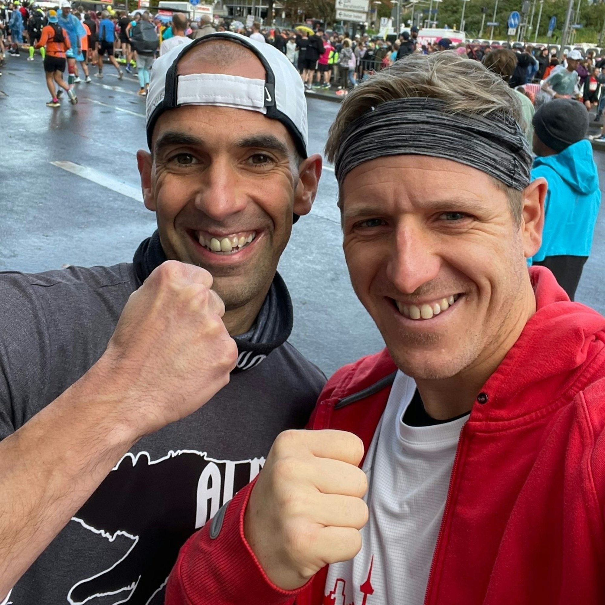 Volker Daniels (l.) und Markus Ramers zeigen grinsend geballte Fäuste in die Kamera. Im Hintergrund befindet sich eine Menschenmasse.