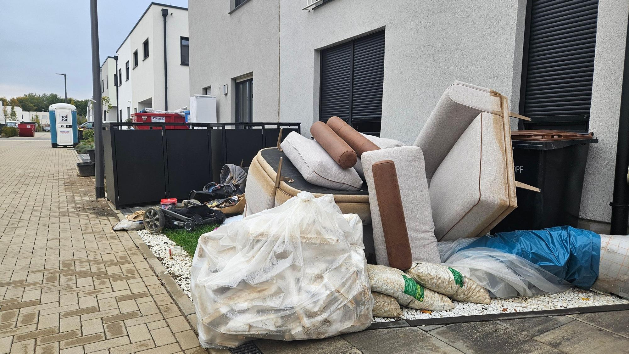 Zu sehen ist Sperrmüll vor einem Haus in einer Neubausiedlung.