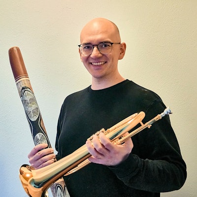Kreisdirigent Nico Haag posiert mit zwei Instrumenten in den Händen.