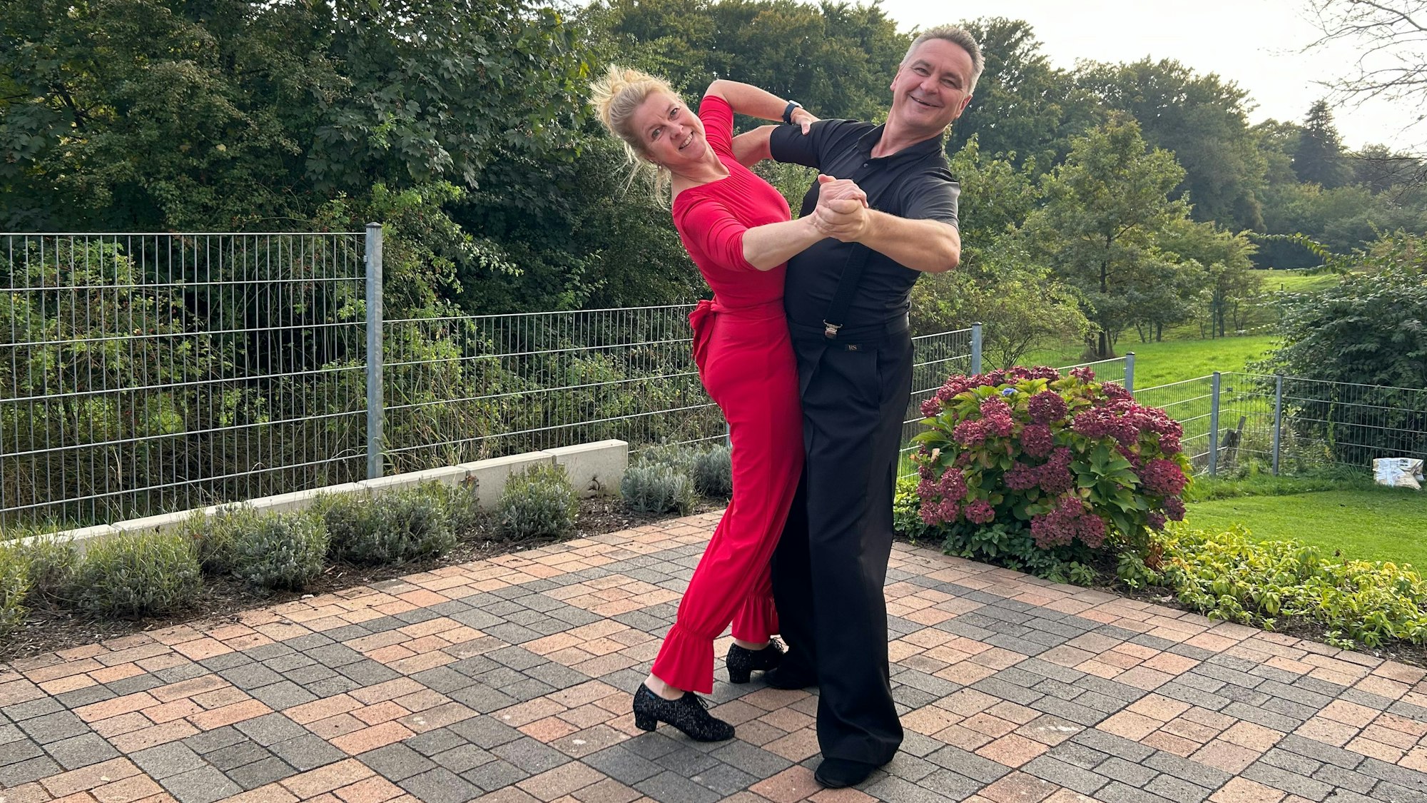 Ein Tanzpaar demonstriert sein Können auf einer Terrasse.