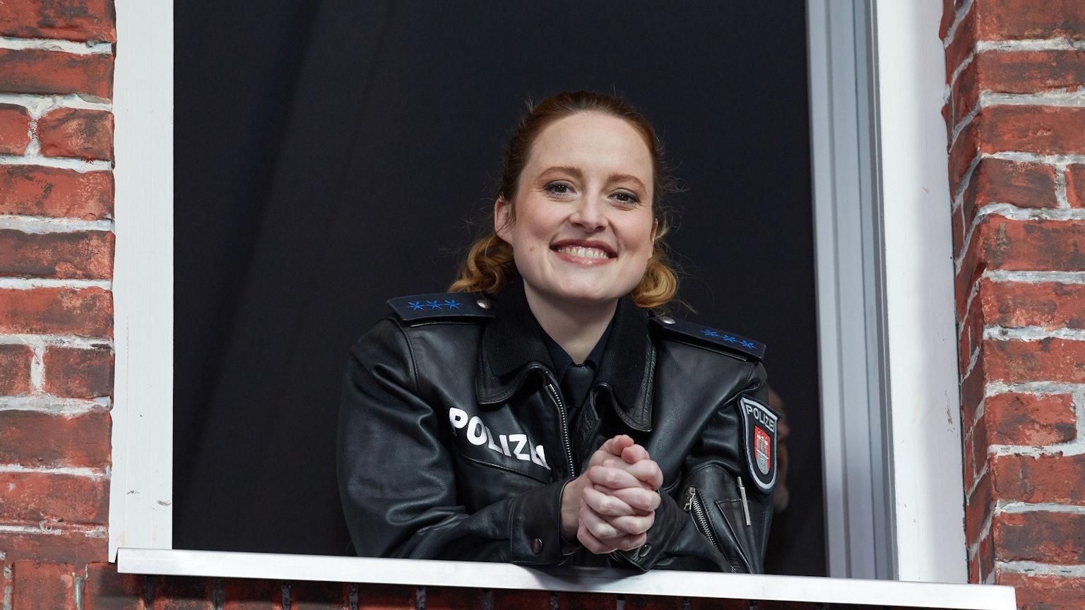 Wanda Perdelwitz lächelt in einer Filmkulisse.