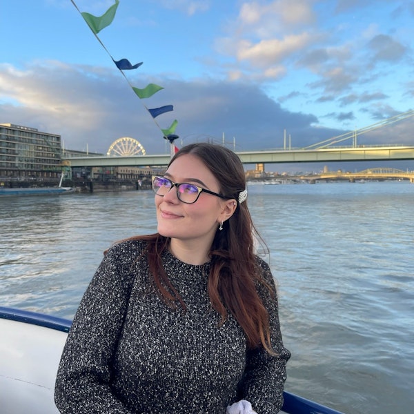 Yuliia Radchenko an einem Fluss. Im Hintergrund eine Brücke.