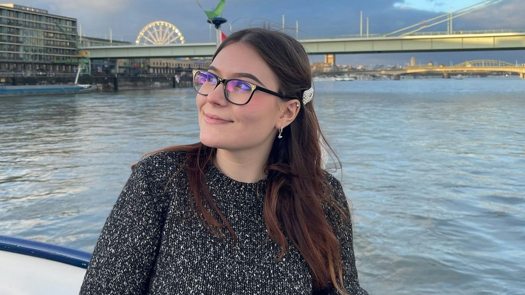 Yuliia Radchenko an einem Fluss. Im Hintergrund eine Brücke.