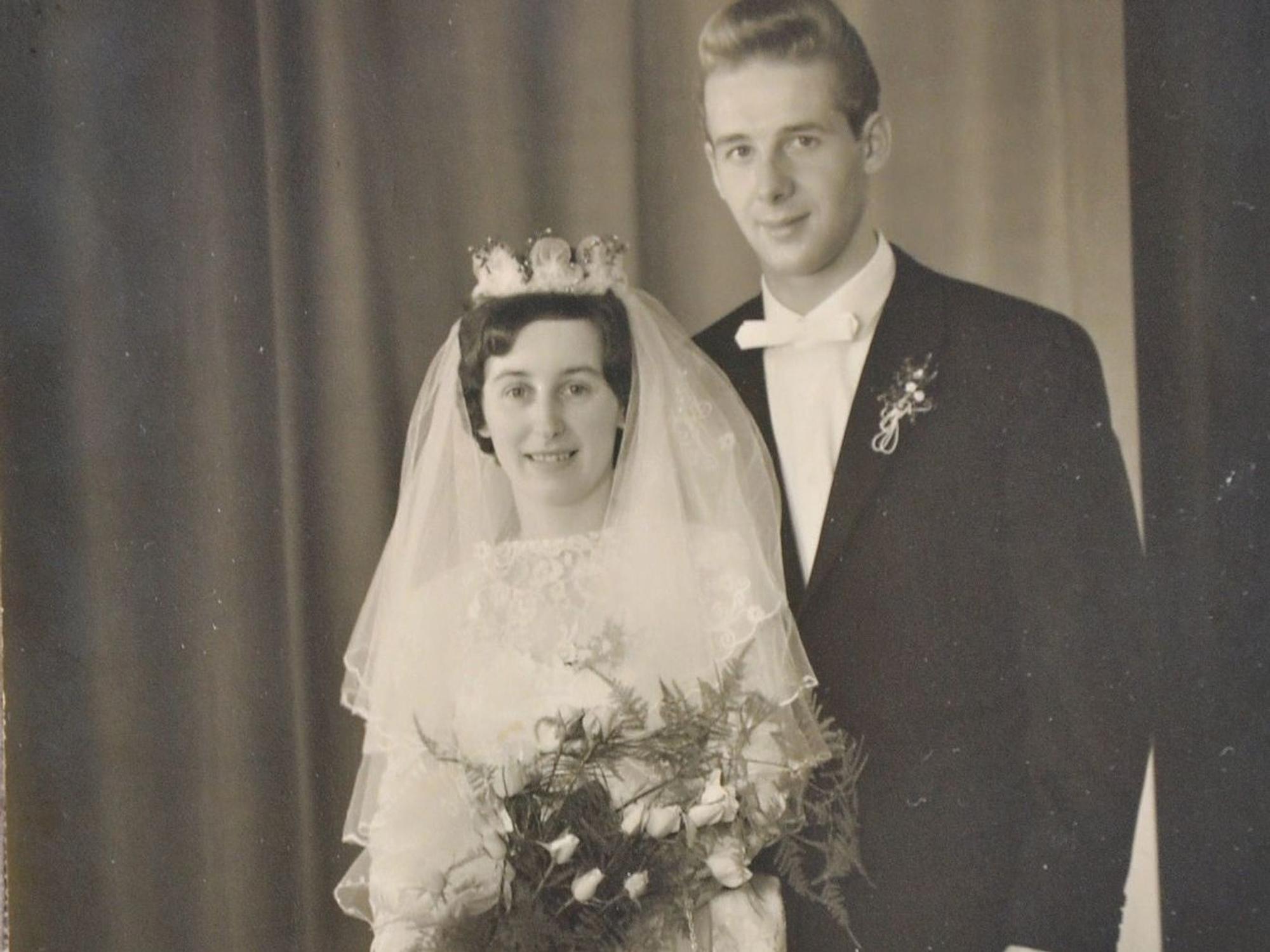 Die Eheleute Magdalena und Johann Bung wurden an ihrem Hochzeitstag fotografiert. Sie trägt ein weißes Kleid mit einem Diadem, er trägt Anzug und Fliege.